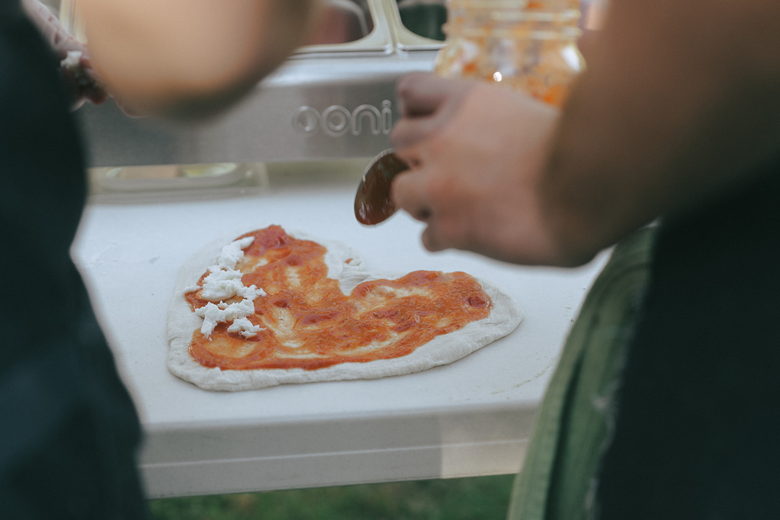 Close up of a heart-shaped pizza being made outside by couples photographer, Elsie Goodman.