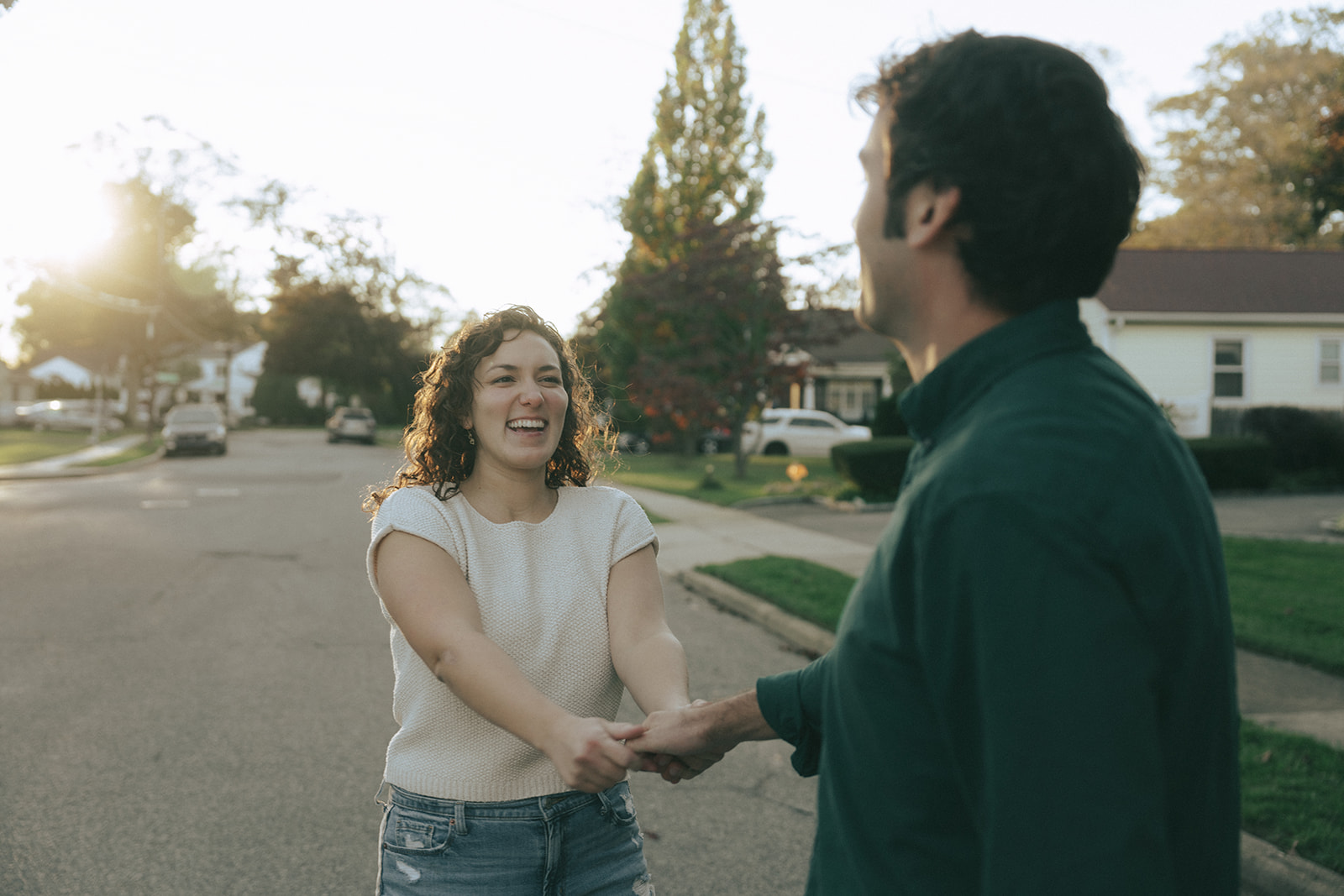 Woman holding a man's hand, looking at him, smiling by wedding and couples photographer Elsie Goodman.