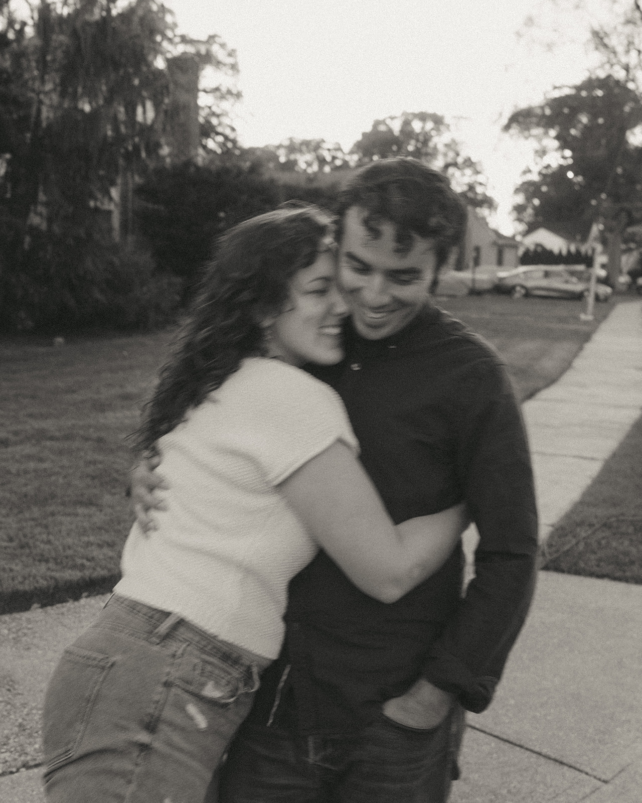 Black and white photo of a couple hugging outside by wedding and couples photographer Elsie Goodman.