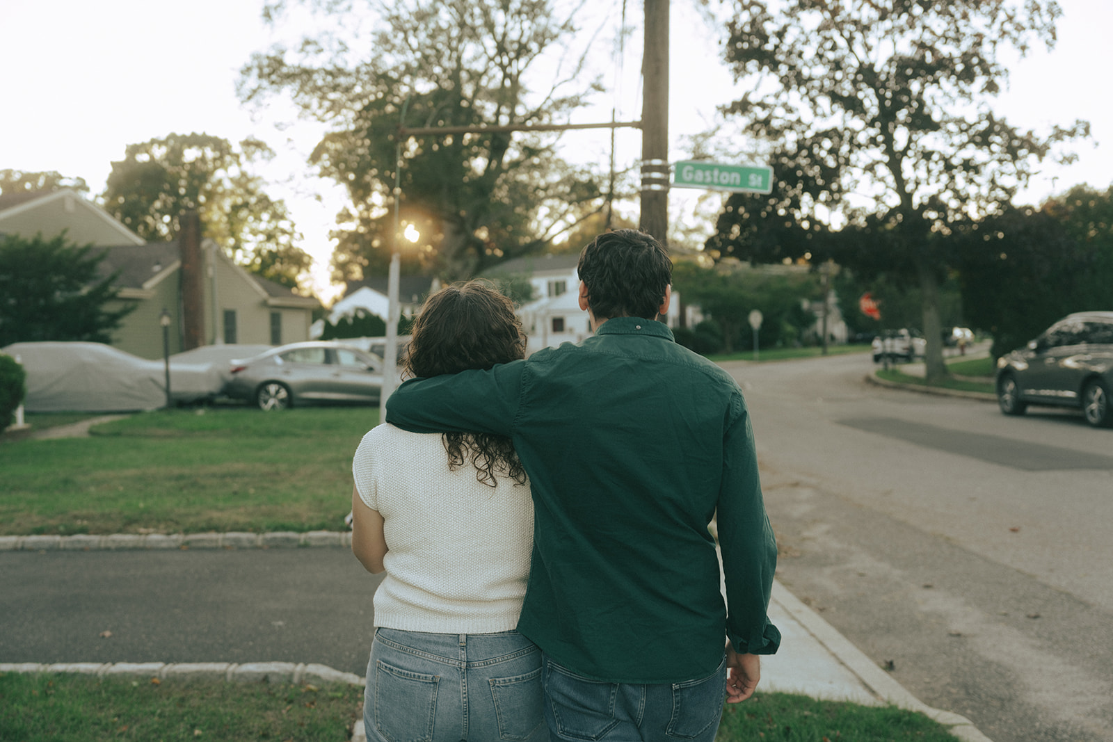 Couple walking down the street, the man has his arm around the woman's shoulders by wedding and couples photographer Elsie Goodman.