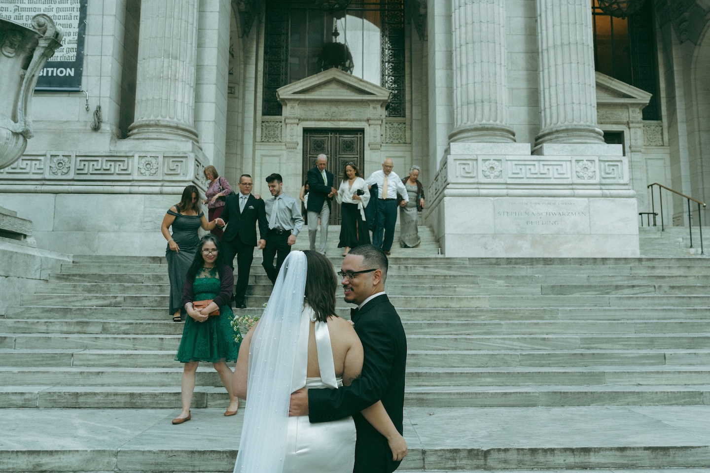 Couple and guests walking down the New York Public Library steps after their elopement