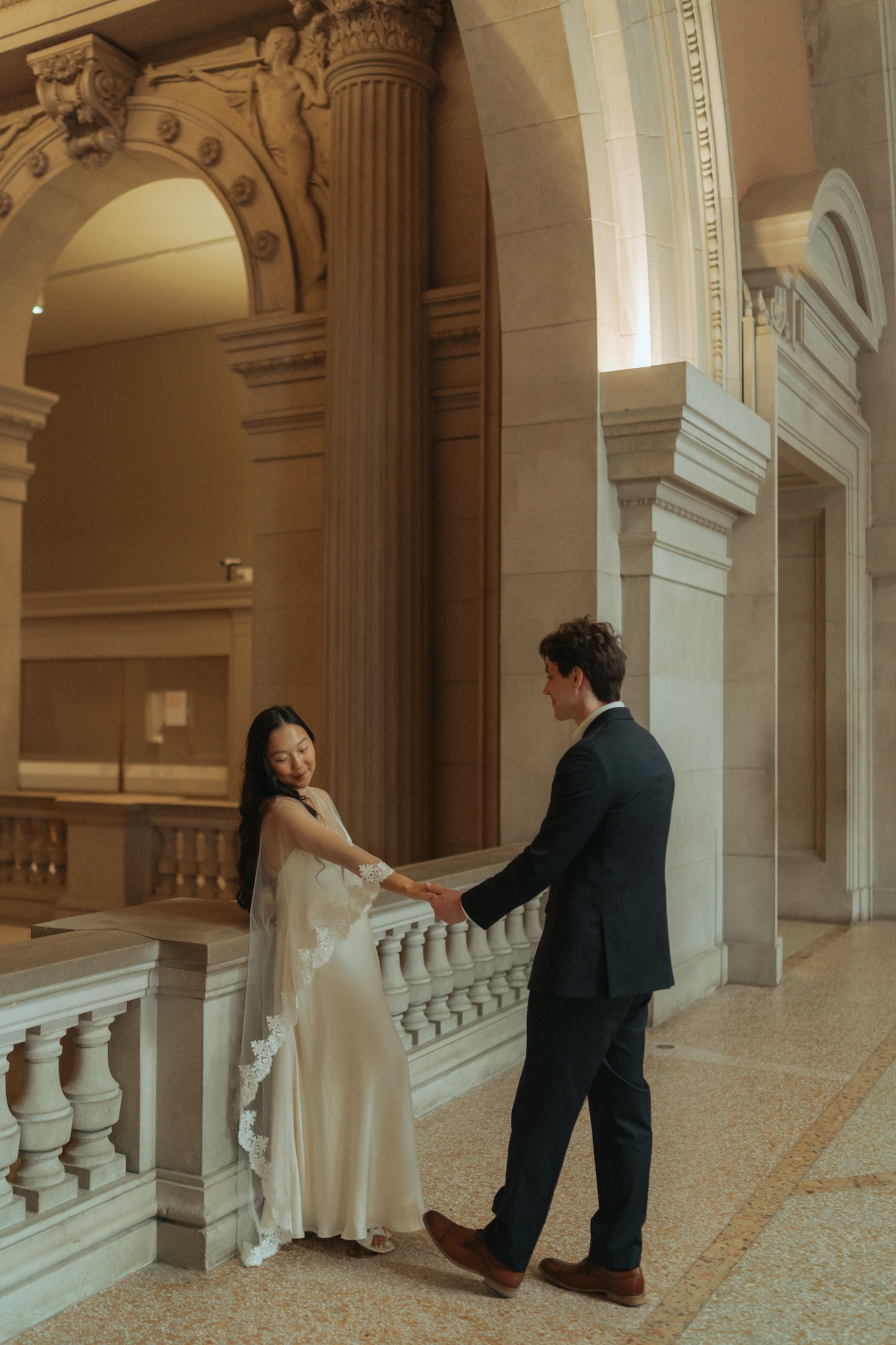 Couple at The Met reaching toward each other during their New York City elopement