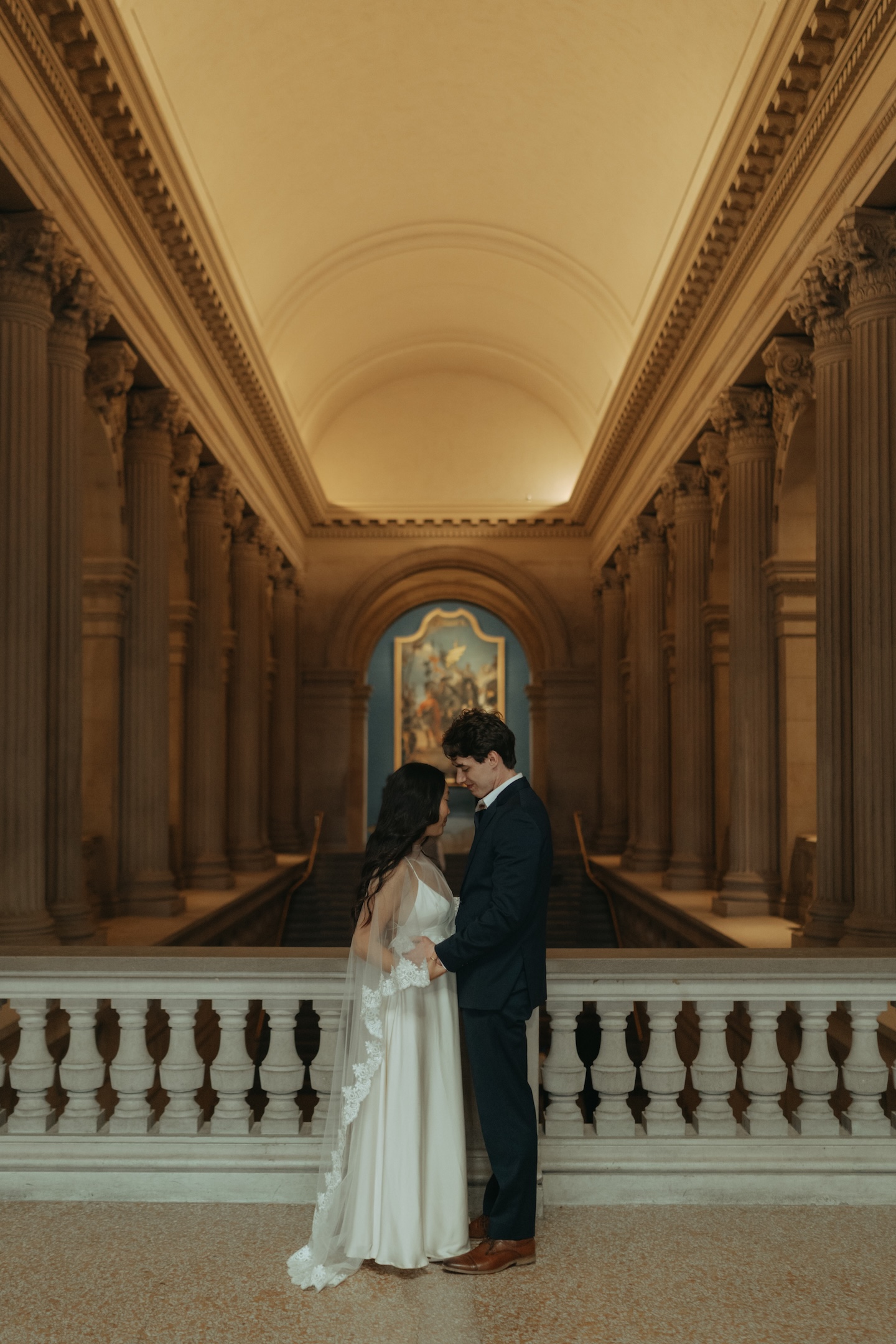 Bride and groom foreheads together inside a grand room at the Met at their NYC elopement