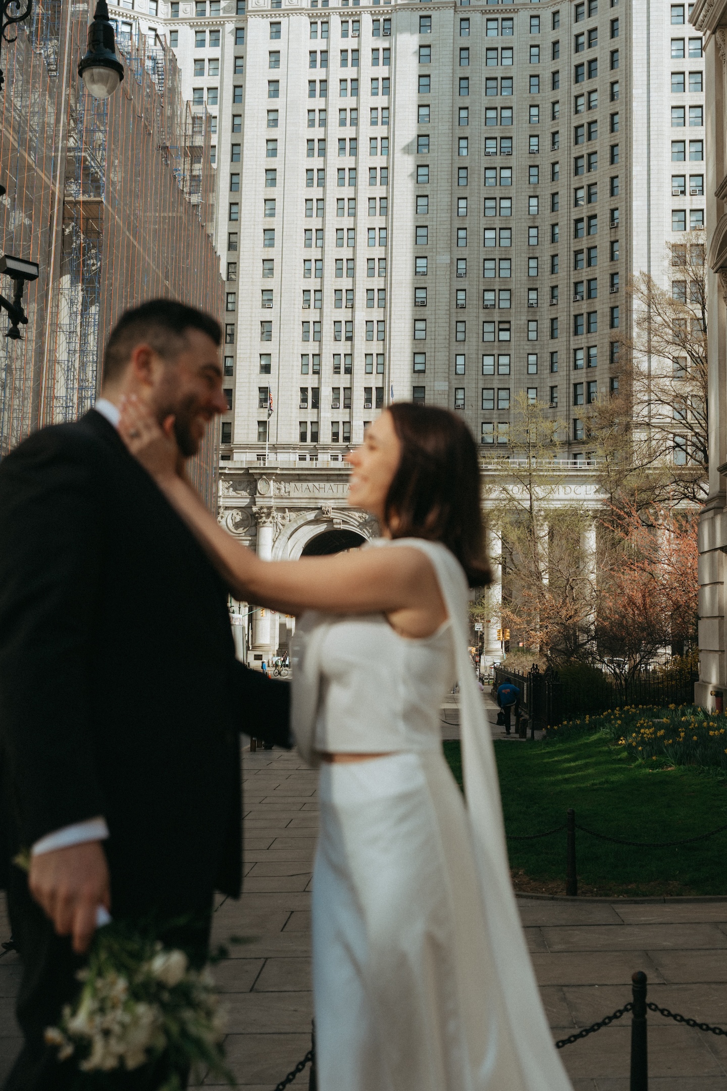 Bride and groom embracing among Manhattan skyscrapers during their NYC elopement
