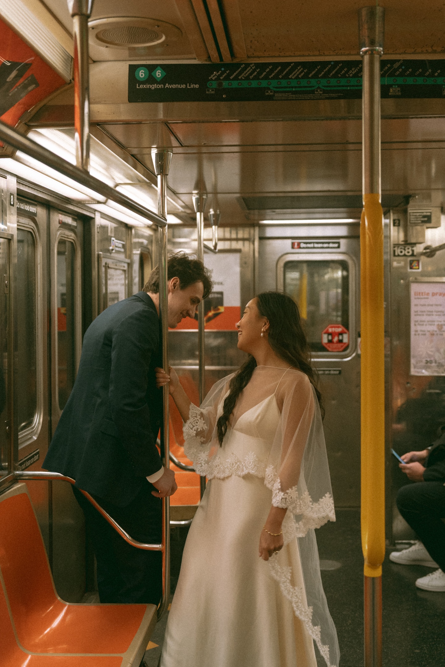 Bride and groom riding the subway in wedding attire during their New York City elopement
