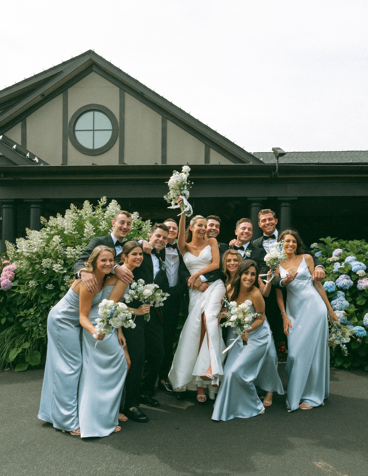 Bridesmaids in dusty blue dresses outdoors, a bridal party grouping for the wedding formal shot list