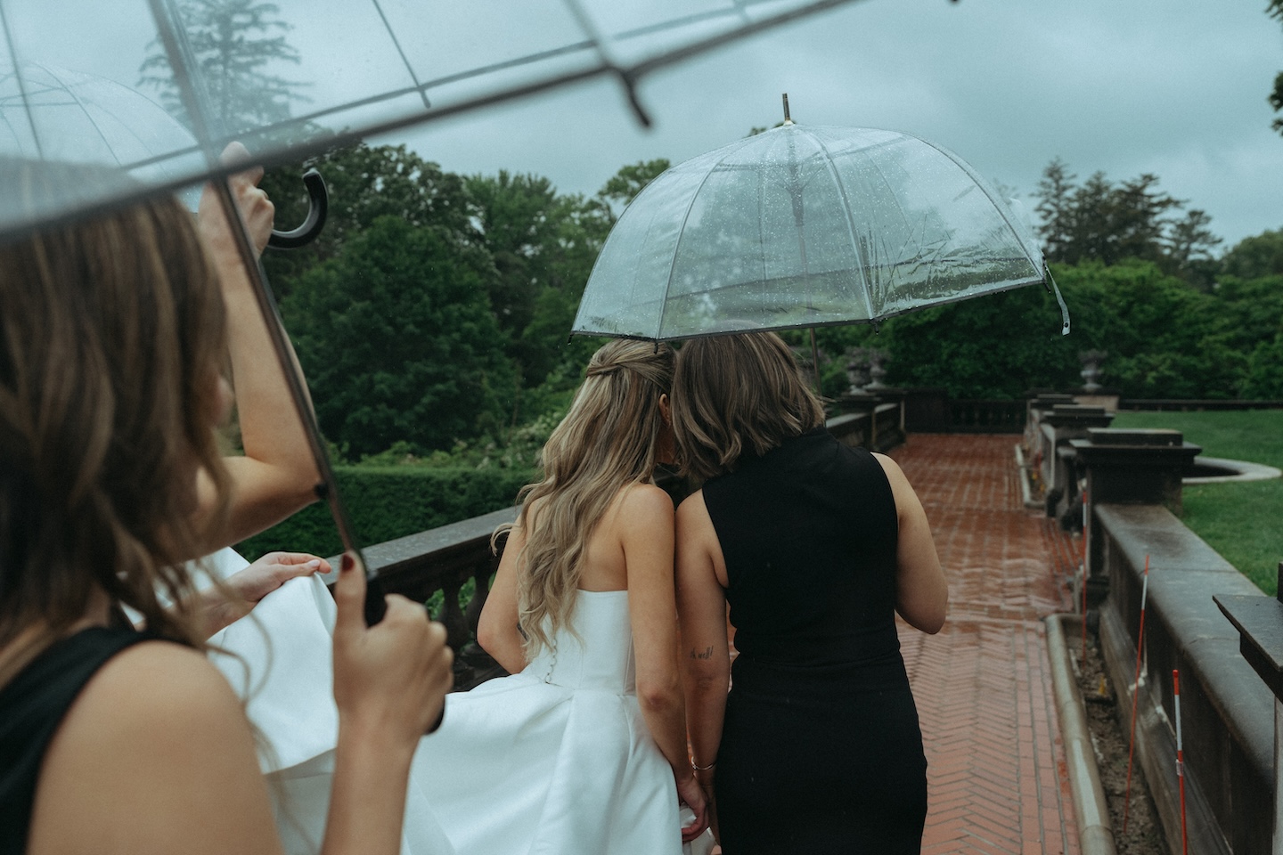Bride sharing an umbrella with her mom, a must-have person on the wedding shot list