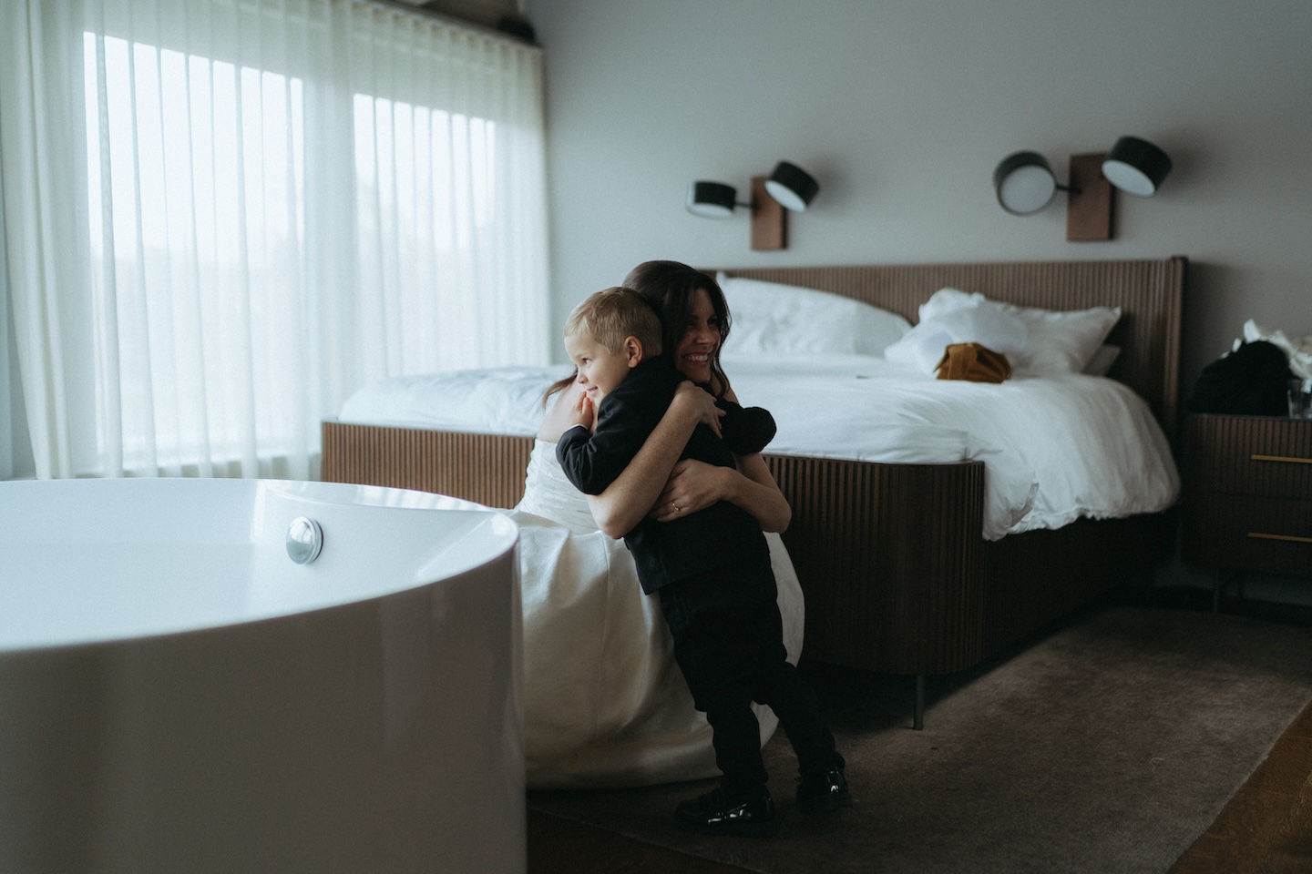 bride hugging a young boy in a suit