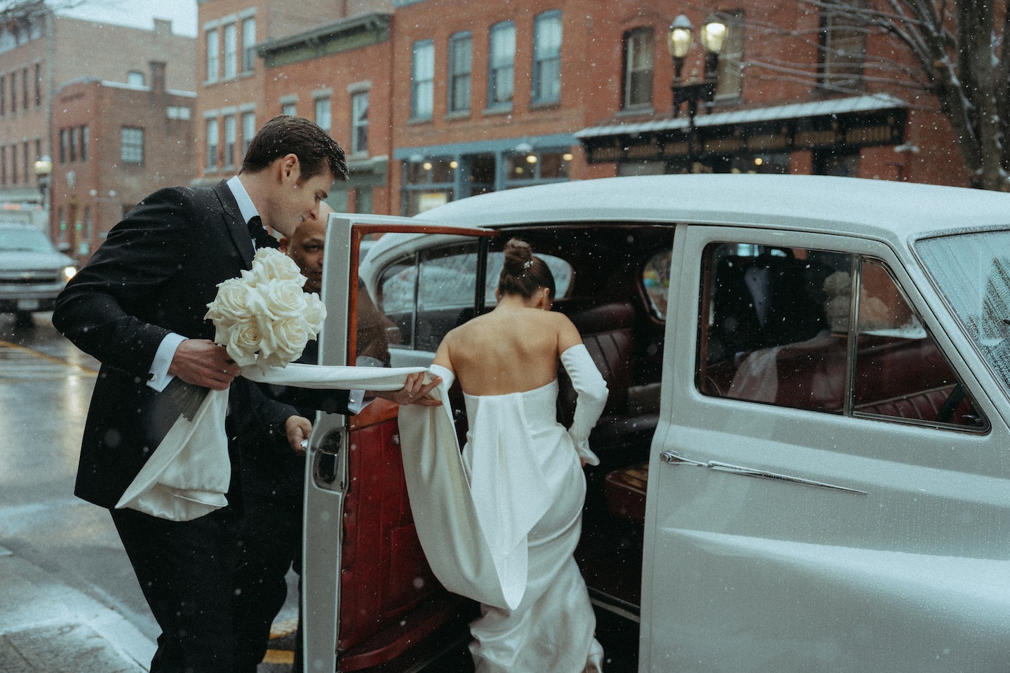 Bride and groom stepping into a vintage car, a wedding shot list send-off image